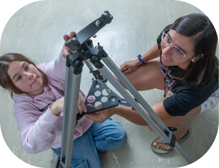 A DU student setting up a telescope for an astronomy project.